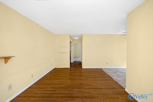 unfurnished room featuring baseboards and wood finished floors