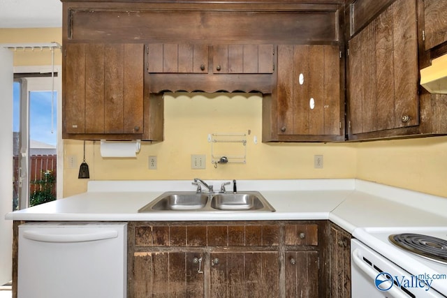 kitchen featuring white appliances, light countertops, a sink, and dark brown cabinetry