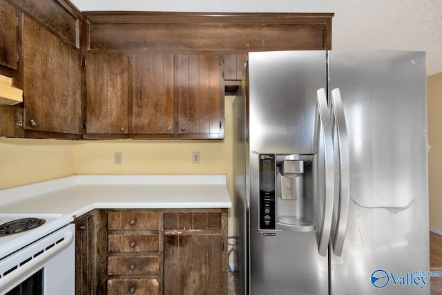 kitchen featuring light countertops, white electric stove, and stainless steel refrigerator with ice dispenser