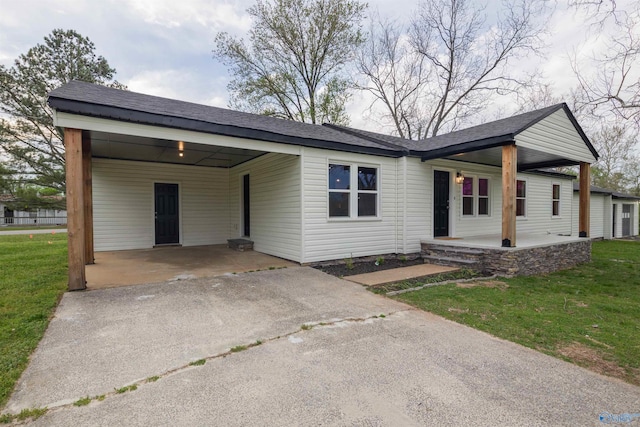 ranch-style home featuring a carport, a porch, and a front lawn