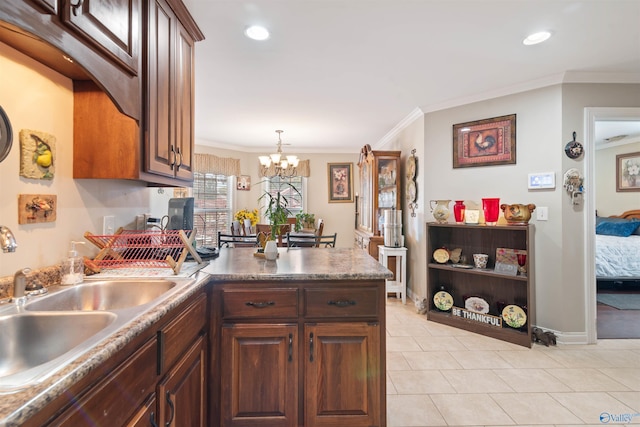 114 Sandi Paige Ln, Huntsville, AL 35811 - kitchen with a peninsula, a chandelier, crown molding, light tile patterned floors, and decorative light fixtures