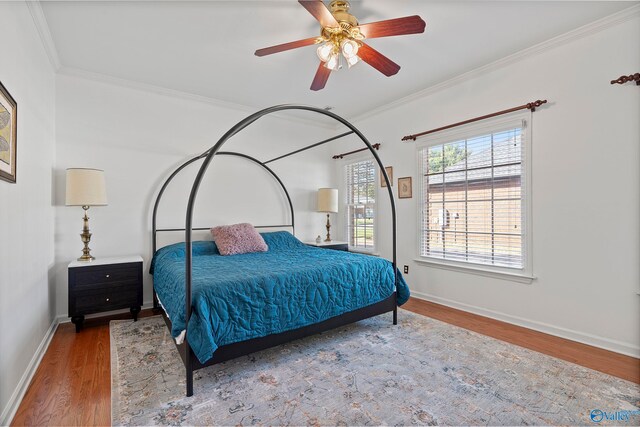 bedroom featuring wood-type flooring, crown molding, and ceiling fan