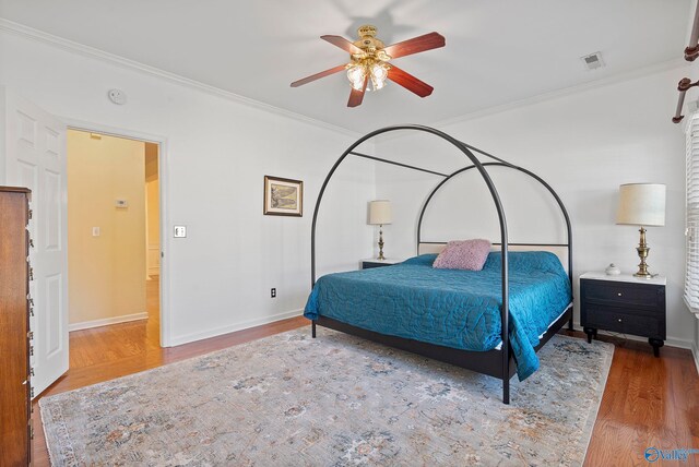 bedroom with crown molding, hardwood / wood-style flooring, and ceiling fan