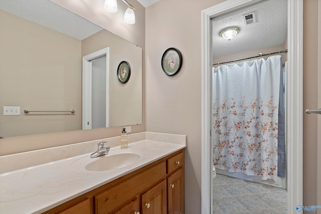 bathroom with a shower with curtain, toilet, vanity, and a textured ceiling