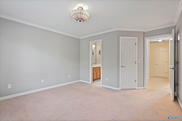 unfurnished bedroom with light carpet, connected bathroom, and crown molding