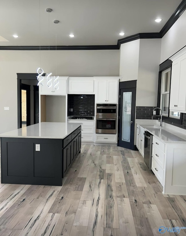 kitchen with stainless steel appliances, sink, hanging light fixtures, and white cabinets