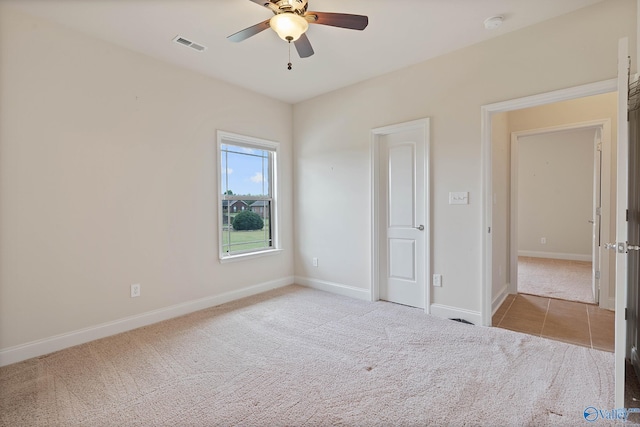 unfurnished bedroom featuring light colored carpet and ceiling fan