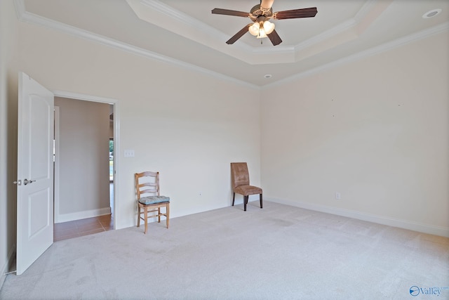 sitting room featuring light colored carpet, ceiling fan, ornamental molding, and a raised ceiling