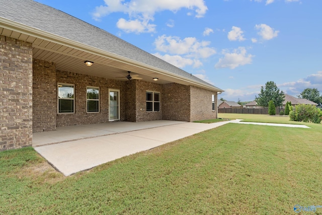 rear view of property featuring a lawn, ceiling fan, and a patio area