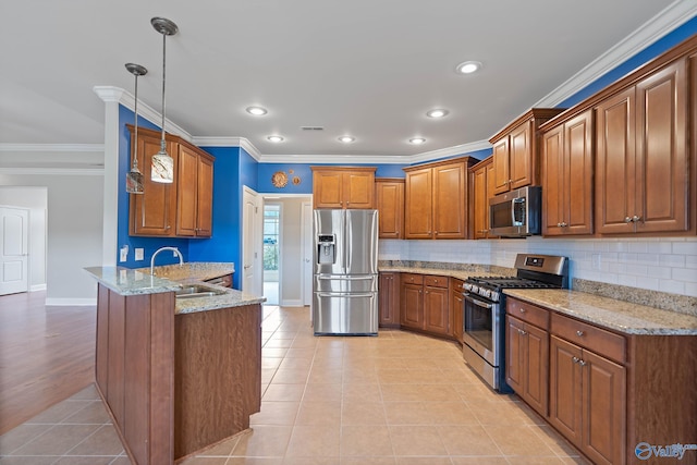 kitchen with light stone countertops, hanging light fixtures, stainless steel appliances, sink, and kitchen peninsula