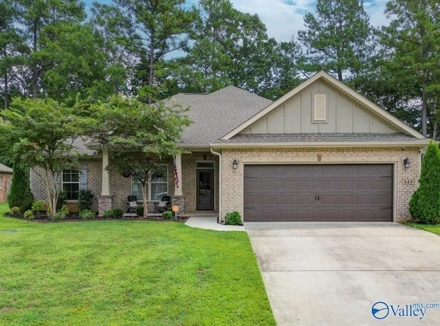 craftsman inspired home with a garage, a front yard, concrete driveway, and brick siding