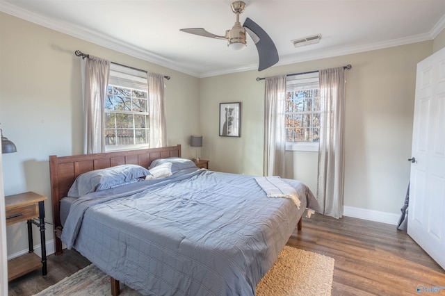 bedroom with dark hardwood / wood-style flooring, crown molding, and ceiling fan