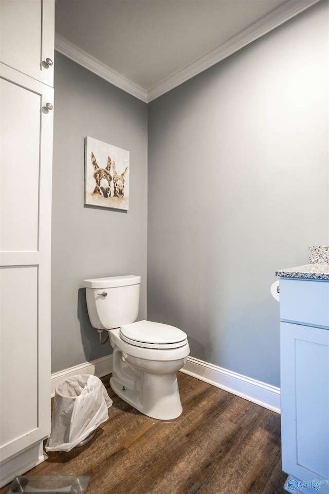 bathroom featuring crown molding, vanity, hardwood / wood-style flooring, and toilet