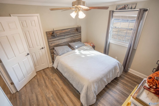 bedroom featuring a closet, crown molding, dark hardwood / wood-style floors, and ceiling fan