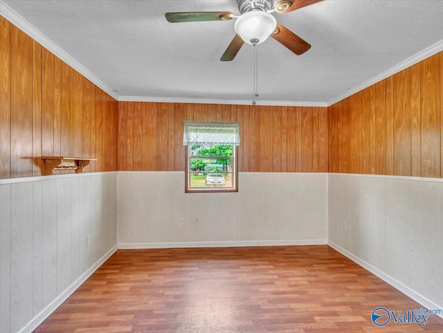17441 E Limestone Rd, Athens, AL 35613 - spare room featuring wood finished floors, a textured ceiling, ceiling fan, wooden walls, and ornamental molding