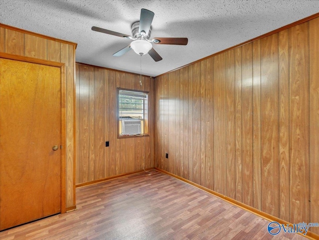 17441 E Limestone Rd, Athens, AL 35613 - empty room with wood finished floors, wooden walls, ceiling fan, baseboards, and a textured ceiling