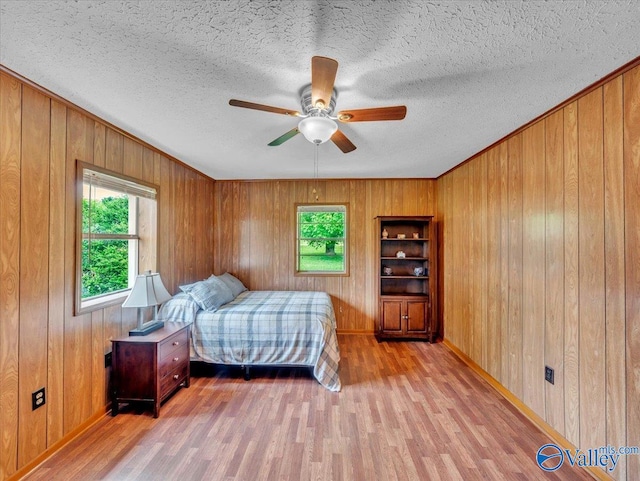 17441 E Limestone Rd, Athens, AL 35613 - bedroom with multiple windows, light wood-style flooring, wooden walls, baseboards, and a textured ceiling