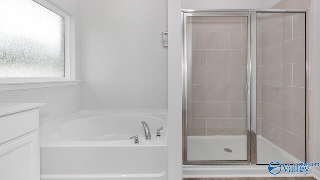 bathroom featuring vanity and shower with separate bathtub