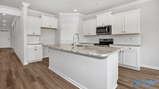 kitchen with an island with sink, stainless steel appliances, white cabinetry, and sink