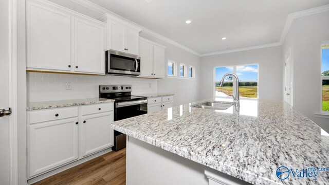 kitchen featuring white cabinetry, sink, a kitchen island with sink, appliances with stainless steel finishes, and light wood-type flooring