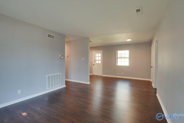 spare room featuring dark wood-type flooring