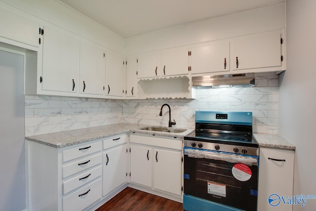 kitchen featuring sink, backsplash, electric range, and white cabinets