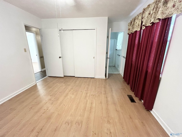 1313 Barry Rd, Anniston, AL 36206 - unfurnished bedroom featuring baseboards, visible vents, light wood-type flooring, and ensuite bathroom