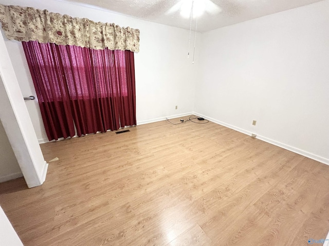 1313 Barry Rd, Anniston, AL 36206 - empty room featuring ceiling fan, visible vents, baseboards, a textured ceiling, and wood finished floors