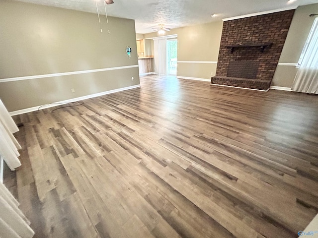1313 Barry Rd, Anniston, AL 36206 - unfurnished living room with baseboards, wood finished floors, a ceiling fan, and a fireplace
