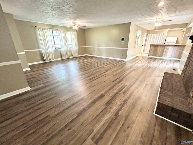 1313 Barry Rd, Anniston, AL 36206 - unfurnished living room featuring a textured ceiling, ceiling fan, wood finished floors, and baseboards