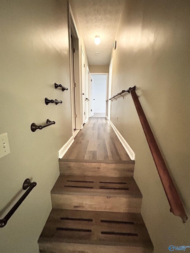 1313 Barry Rd, Anniston, AL 36206 - stairway featuring a textured ceiling, wood finished floors, and baseboards