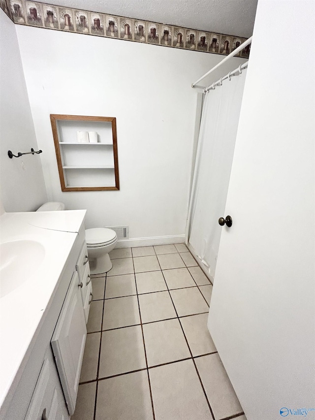 1313 Barry Rd, Anniston, AL 36206 - full bathroom featuring tile patterned floors, a shower with shower curtain, toilet, vanity, and a textured ceiling