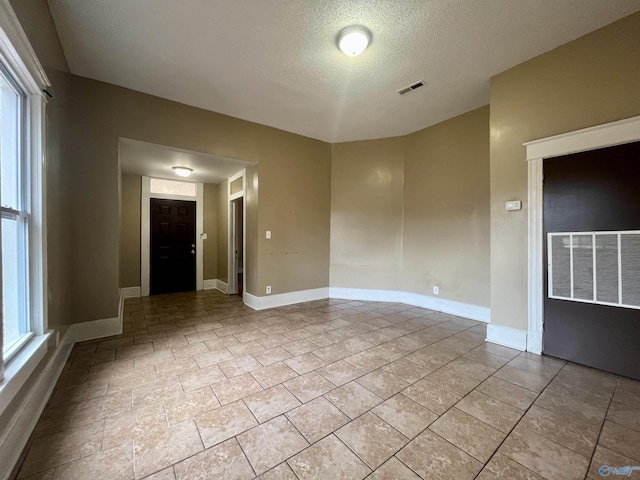 spare room with a textured ceiling