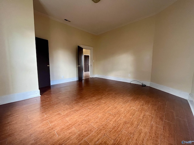 spare room featuring wood-type flooring and crown molding