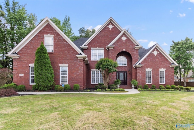 view of front of property with a front lawn and brick siding