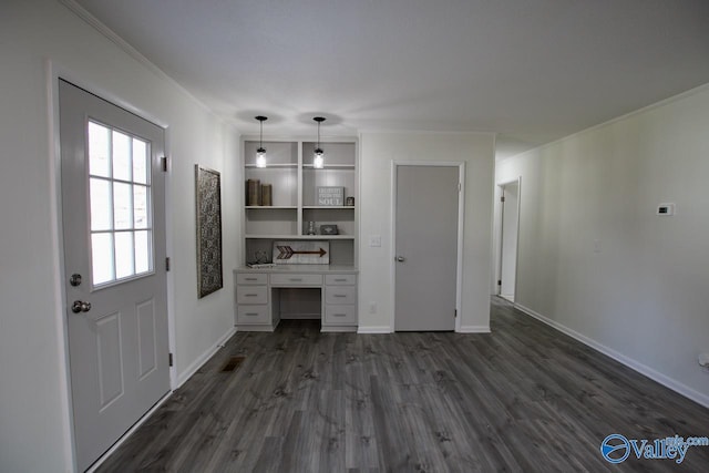 unfurnished office with ornamental molding, dark wood-type flooring, and built in desk