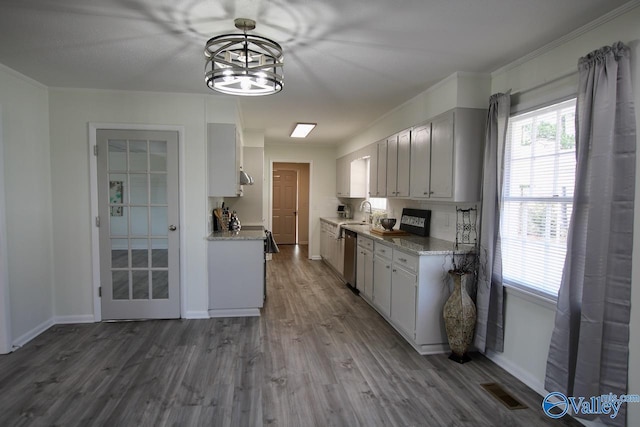 kitchen with white cabinetry, wood-type flooring, dishwasher, sink, and hanging light fixtures