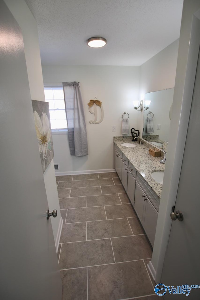 bathroom with vanity and a textured ceiling