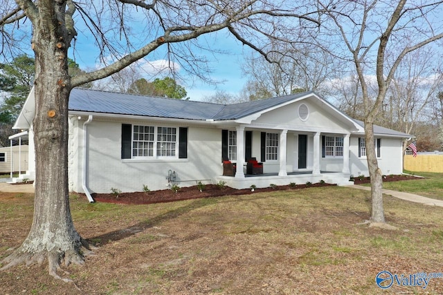 ranch-style home featuring covered porch and a front lawn