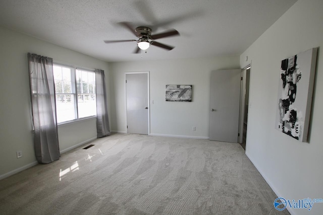 carpeted spare room with ceiling fan and a textured ceiling
