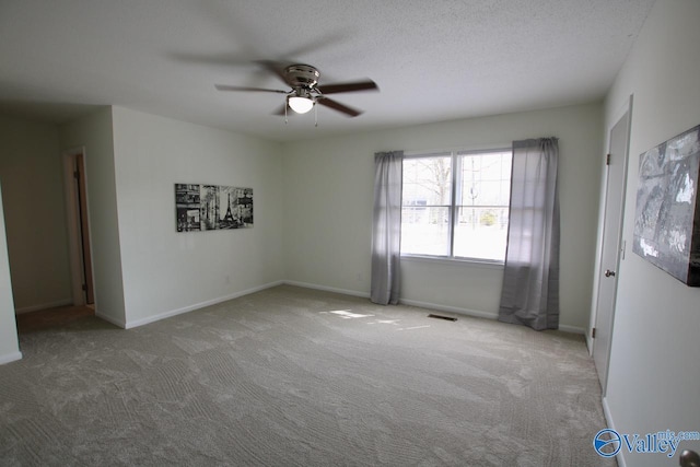 carpeted spare room with ceiling fan and a textured ceiling