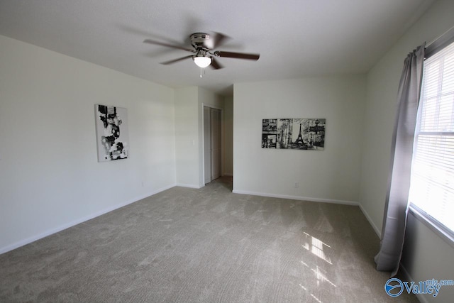 carpeted spare room with ceiling fan