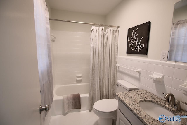 full bathroom with vanity, toilet, shower / tub combo, and tile walls
