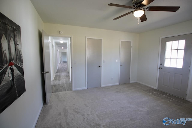 unfurnished bedroom featuring light colored carpet and ceiling fan