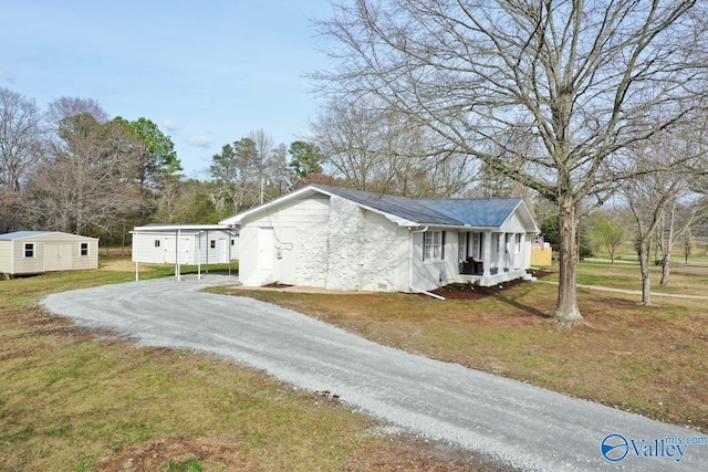 view of property exterior featuring a carport, a porch, a yard, and a shed