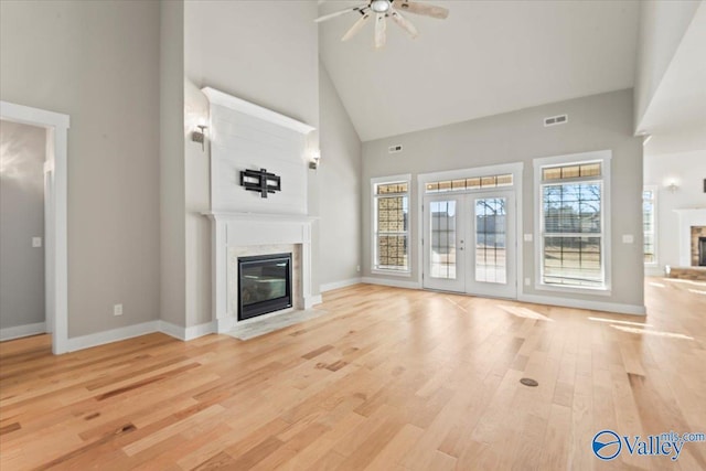 unfurnished living room featuring french doors, high vaulted ceiling, ceiling fan, and light hardwood / wood-style flooring