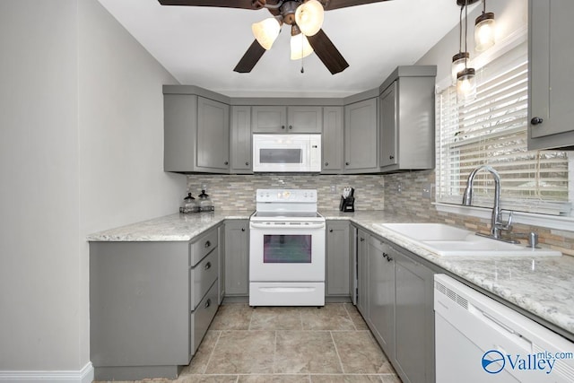 kitchen featuring decorative light fixtures, sink, gray cabinetry, decorative backsplash, and white appliances