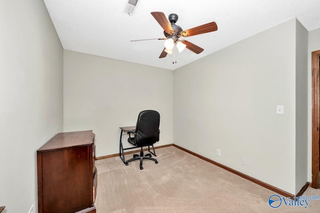 unfurnished office with light colored carpet, a textured ceiling, and ceiling fan