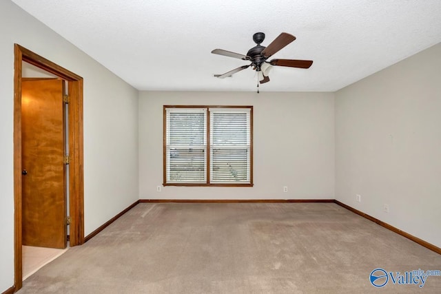 carpeted empty room featuring ceiling fan and a textured ceiling