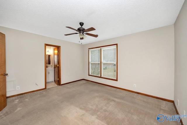 empty room featuring ceiling fan, light carpet, and a textured ceiling